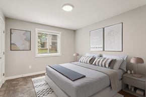 Marietta apartment for rent - 2-Bedroom Apartments in Marietta, GA - The Park on Windy Hill - A Bedroom Features Striped Pillows, Matching Nightstands With Lamps, Framed Wall Art, And A Window With White Blinds.