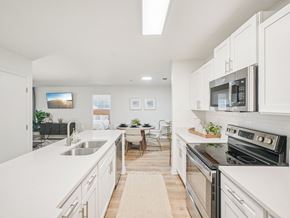 Apex apartment for rent - A modern kitchen with white cabinets and stainless steel appliances.