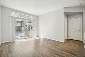 Salt Lake City apartment for rent - Model Living Room with Wood-Style Flooring and Patio Accessibility at Altitude on Fifth Apartments located in Salt Lake City, UT.