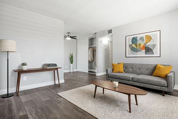 Las Vegas apartment for rent - A living room with a grey couch, a wooden table, and a painting on the wall.