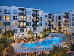Dallas apartment for rent - an apartment building with a swimming pool at night