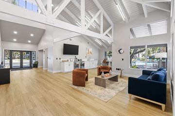 Sarasota apartment for rent - A spacious living room with a blue couch and a wooden floor.