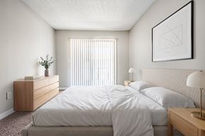 Largo apartment for rent - A bedroom with a large bed and a nightstand with a lamp.