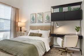 Dallas apartment for rent - Luxury Studio Apartments Bishop Arts District, TX - Banyan Flats - Bright Studio Bedroom With Large Windows, Neutral Bedding, Modern Desk Nook, And Built In Shelving