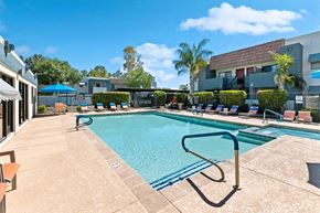 Chandler apartment for rent - a swimming pool with lounge chairs and umbrellas in front of a building