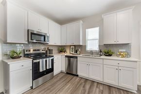 Pflugerville apartment for rent - Pflugerville, TX Pet-Friendly Single Family Homes for Rent - Banyan Everton - White Kitchen With Stainless Steel Range, Microwave, Subway Tile Backsplash, And Granite Countertops