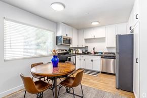 San Diego apartment for rent - A kitchen with a table and chairs and a refrigerator.