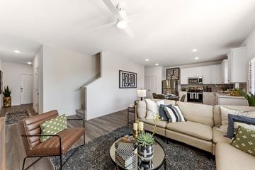 Pflugerville apartment for rent - A living room with a brown leather chair and a beige couch with a glass coffee table in the middle.