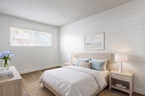 San Diego apartment for rent - A bedroom with a large bed, a nightstand with a lamp, and a painting on the wall.