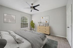 Lawrenceville apartment for rent - a bedroom with a large bed and a ceiling fan