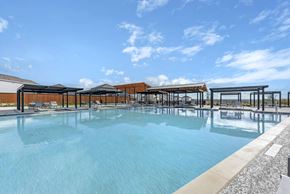 Pflugerville apartment for rent - A large outdoor swimming pool with a sun lounger area.
