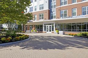 Watertown apartment for rent - A brick building with a white awning and a sign that says