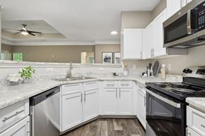 Stockbridge apartment for rent - Model apartment kitchen with white cabinets and a stove and a microwave