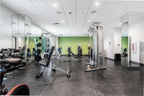 Aurora apartment for rent - A gym with a variety of equipment including a rowing machine, a bench press, and a squat rack.