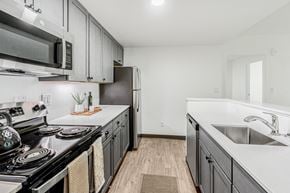 Aurora apartment for rent - A kitchen with a black stove top oven and a black microwave above it.