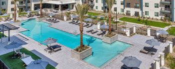 Resort-style pool w/ sundeck, poolside loungers, & café tables