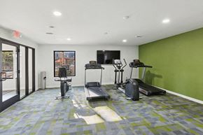 Tucson apartment for rent - Studio Apartments Eastside Tucson, AZ - Tanque Verde - A Fitness Center With Treadmills, Exercise Bike, Elliptical Machine, Wall-Mounted Television, And Floor-to-Ceiling Windows.
