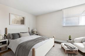 Phoenix apartment for rent - One-Bedroom Affordable Apartments in Camelback East Village, AZ - Arcadia on 49th - A Bright Bedroom With A White Upholstered Bed, Neutral Bedding, Side Tables With Lamps, And A Large Window.