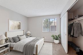 Federal Way apartment for rent - Pet-Friendly Apartments in Federal Way, WA - Sunset Three Twenty - A Bedroom With A White Bed With Gray Bedding, Two White Nightstands With Lamps, And A Window.