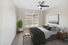 Garland apartment for rent - Three-Bedroom Apartments in Garland, TX - The Belmont at Duck Creek - A Bedroom With A Ceiling Fan, Window With Blinds, Nightstand Decor, Wall Art, And Potted Plant.