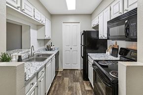 Chandler apartment for rent - Apartments in Chandler, AZ, With In-Unit Washer and Dryer - Chandler Ridge - A Kitchen Features White Cabinets, Speckled Countertops, Double Sink, Black Refrigerator, And Electric Stove.