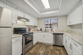 Renton apartment for rent - Model Kitchen with White Cabinets and Wood-Style Flooring at Grammercy Apartments located in Renton, WA.