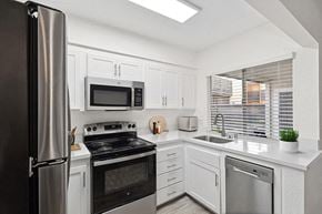 Santa Ana apartment for rent - Dog-Friendly Apartments in Santa Ana, CA - Horizon - A Kitchen With A Stainless Steel Refrigerator, An Electric Range With Microwave, Quartz Style Countertops, And A Deep Sink.