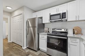 Marietta apartment for rent - 2-Bedroom Apartments in Marietta, GA - Laurel Hills Preserve - A Kitchen Equipped With A Stainless Steel Refrigerator, Electric Range And Microwave, Shaker Cabinets, And Subway Tile Backsplash.