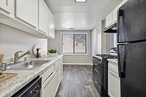 Silver Spring apartment for rent - Silver Spring, MD Apartments for Rent - Spring Parc - Updated Galley Kitchen With White Cabinets, Marble Look Counters, Gas Range, Black Refrigerator, And Wood Style Flooring