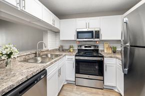 Jacksonville apartment for rent - Pet-Friendly Apartments in Westside Jacksonville, FL - Westland Park - A Kitchen Features White Cabinets, Granite Countertops, Stainless Steel Appliances, And A Double Sink.