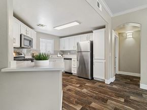 Moreno Valley apartment for rent - A kitchen with white cabinets and a wooden floor.