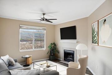Moreno Valley apartment for rent - A living room with a grey couch, a fireplace, a ceiling fan, and a painting on the wall.