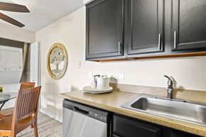 Lakewood apartment for rent - A kitchen with a wooden chair and a clock on the wall.