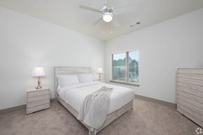 Conyers apartment for rent - A bedroom with a bed, nightstand, and window.