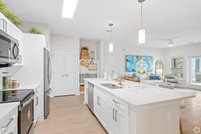 Cocoa apartment for rent - A modern kitchen with white cabinets and appliances.