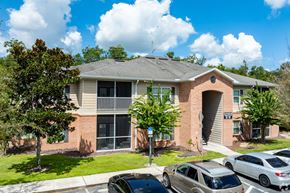 Dade City apartment for rent - A residential building with a parking lot in front.