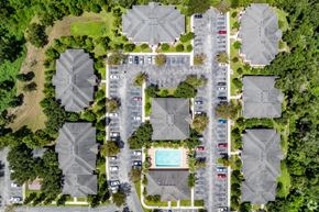 Dade City apartment for rent - A bird's eye view of a residential area with houses, cars, and a pool.