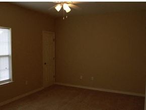 Pensacola apartment for rent - A room with a ceiling fan and a door at Arbours at Ensley Apartments, Pensacola, FL 32514