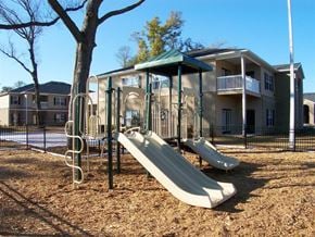 Pensacola apartment for rent - A beige building with a balcony and a staircase at Arbours at Ensley Apartments, Pensacola, 32514
