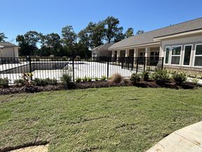 Lake Charles apartment for rent - A house with a black fence and a green lawn at Arbours at Lake Charles, Lake Charles, Louisiana