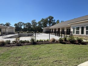 Lake Charles apartment for rent - A black fence surrounds a building with a white roof at Arbours at Lake Charles, Lake Charles, LA