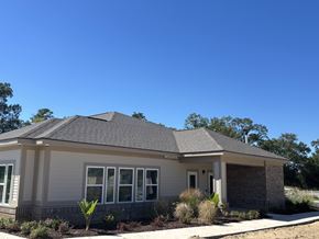 Lake Charles apartment for rent - A house with a grey roof and white walls with a small garden in front at Arbours at Lake Charles, Lake Charles