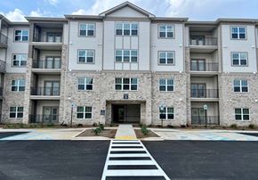 Huntsville apartment for rent - A large apartment building with a crosswalk in front.at Arbours at Moores Mill, Huntsville, AL 35811