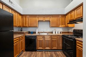 Montgomery apartment for rent - A kitchen with wooden cabinets and black appliances.