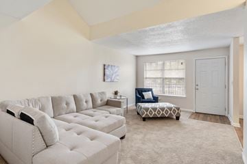Montgomery apartment for rent - A living room with a white couch and a patterned ottoman.