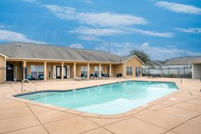 Montgomery apartment for rent - A large swimming pool in front of a building with a sunny sky.