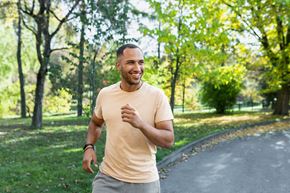 Cocoa apartment for rent - A man in a beige shirt and grey shorts is running on a path in a park at Arbours at Cocoa Landing, Cocoa, FL, 32926