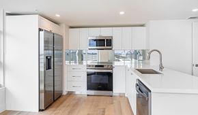 Miami apartment for rent - Modern kitchen with white cabinets and stainless appliances at The Hamilton Apartments, Florida