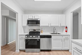 Annapolis apartment for rent - A modern kitchen with white cabinets and stainless steel appliances.