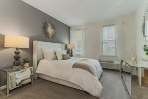 Long Branch apartment for rent - Master bedroom with neutral tones and gray accent wall at Pier Village Apartments, New Jersey, 7740